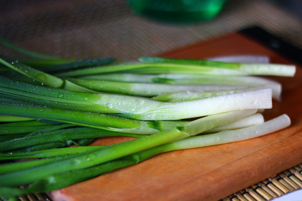 Photo of scallions on a cutting board from Eleonora Sky from Pexels