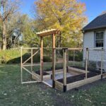 Raised bed garden in front of yellow tree